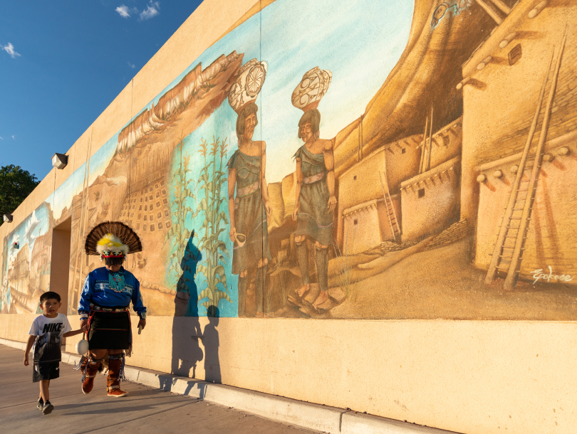 Man and boy walking by mural